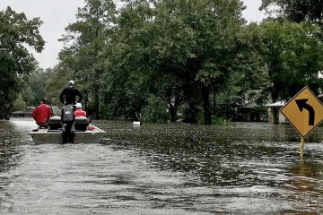 rescuers on boat on flooded street