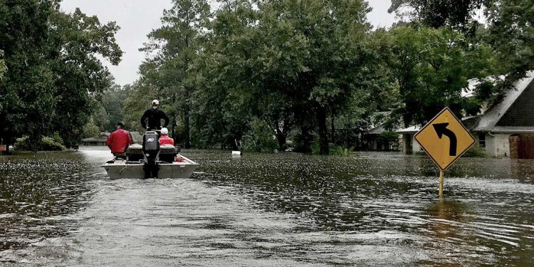 rescuers on boat on flooded street